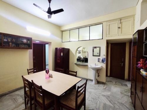 a dining room with a table and a sink at Spacious 3BHK House opp South City Mall in Kolkata