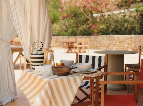 a table with two cups and bowls on a patio at Llucatx Menorca in Son Parc