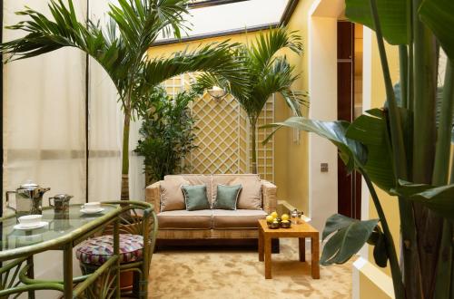 a living room with a couch and some plants at Les Suites Cinabre in Paris