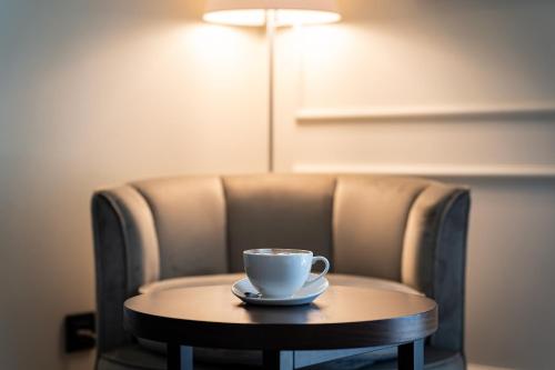 a coffee cup sitting on a table in a chair at Hotel California by Aycon in Sveti Stefan