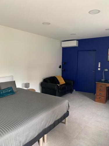 a bedroom with a bed and a blue wall at L'HERMANCERIE in Priay