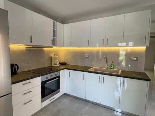 a kitchen with white cabinets and a sink at Arian Apartments in Argostoli