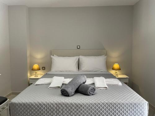 1 dormitorio con 1 cama con 2 toallas y 2 lámparas en Arian Apartments, en Argostoli