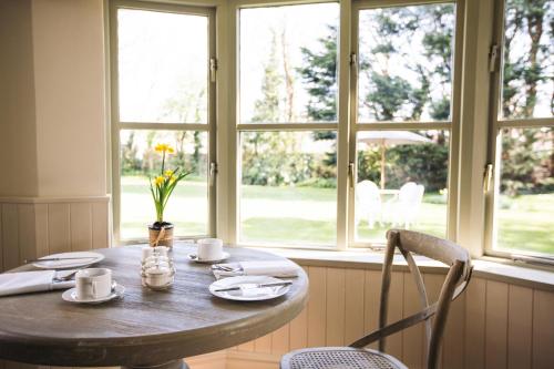 a wooden table with two chairs and a window at The Broadmead Boutique B&B in Tenby