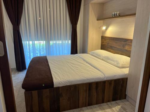 a large bed in a bedroom with a large window at Apart 31 in Cetinje