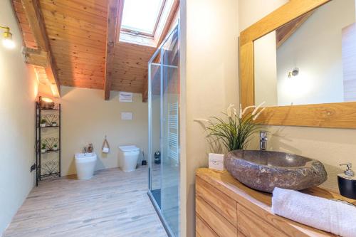 La salle de bains est pourvue d'un lavabo et d'une douche en verre. dans l'établissement Cascina Liebe con Idromassaggio, à Ozzano Monferrato