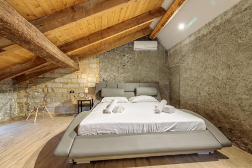 a bedroom with a large bed in a stone wall at Cascina Liebe con Idromassaggio in Ozzano Monferrato
