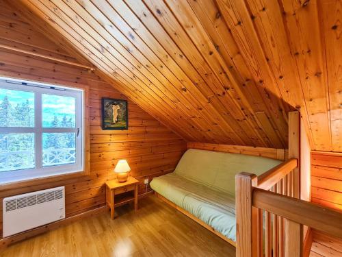 pokój z łóżkiem w drewnianym domku z oknem w obiekcie Chalet confortable avec poêle et terrasse, 3 chambres, garage, animaux admis - FR-1-425-198 w mieście Arâches-la-Frasse