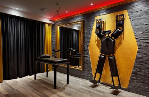 a dressing room with a black chair and a mirror at Metro Elegance Suites in Tel Binyamin
