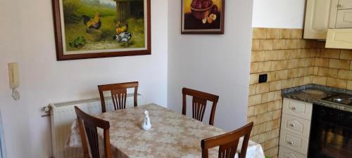 a dining room table with chairs and a painting on the wall at Vila Tahiri 2 in Golem