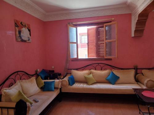 un soggiorno con divano e finestra di Apartement en 1er etage et autre 2eme avec terasse location longue duré a Essaouira