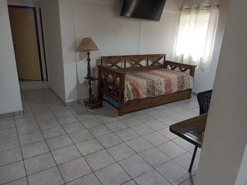 1 dormitorio con 1 cama y 1 lámpara en el suelo de baldosa en Complejo las Palmeras II en Mendoza