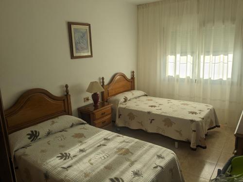 a bedroom with two beds and a window at Alicia Bis in Sanxenxo