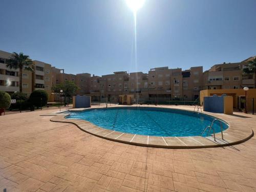 a large pool in the middle of a courtyard at Precioso piso con piscina a 10 min de la playa andando in Roquetas de Mar