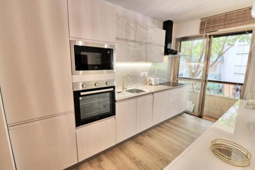 La cuisine blanche est équipée d'un évier et d'un réfrigérateur. dans l'établissement Ref FLEUR - Palmes d'Or Properties, à Cannes