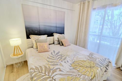 une chambre avec un lit avec une grande fenêtre dans l'établissement Ref FLEUR - Palmes d'Or Properties, à Cannes