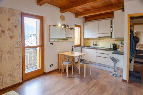 kuchnia ze stołem i krzesłami oraz oknem w obiekcie Allo Villo Lovely Apartment w mieście Ostana