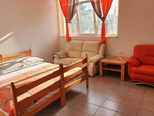 ein Schlafzimmer mit einem Bett, einer Couch und einem Sessel in der Unterkunft Apartments Dani in Izola