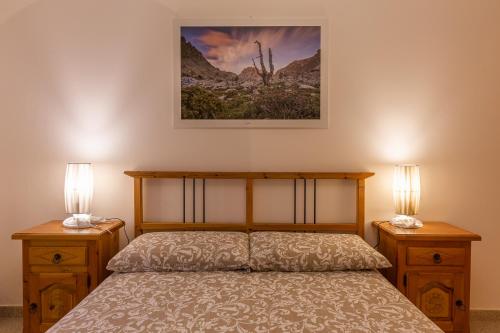 a bedroom with a bed with two nightstands and two lamps at Suite Bertines Panoramica - Borgata di montagna in Casteldelfino