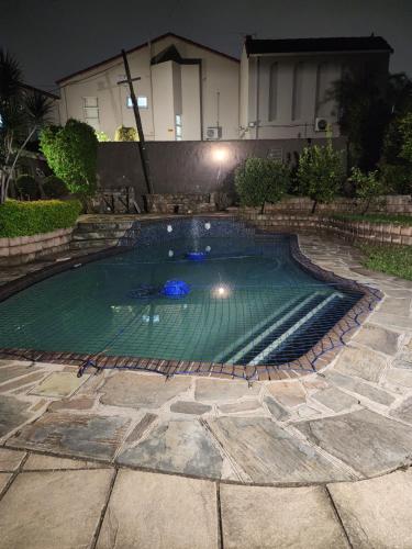 a swimming pool in front of a house at night at Charles Court Guest House in Durban
