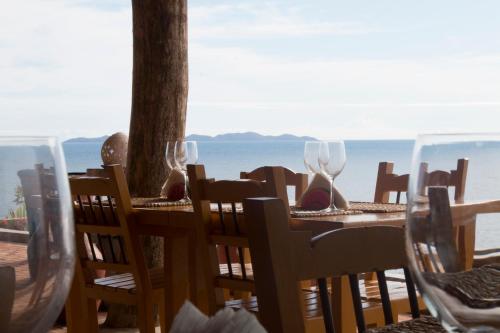 a table with wine glasses and a view of the ocean at Cala Margarita Hotel in Paraguachi
