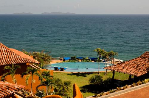 a view of a swimming pool next to the ocean at Cala Margarita Hotel in Paraguachi