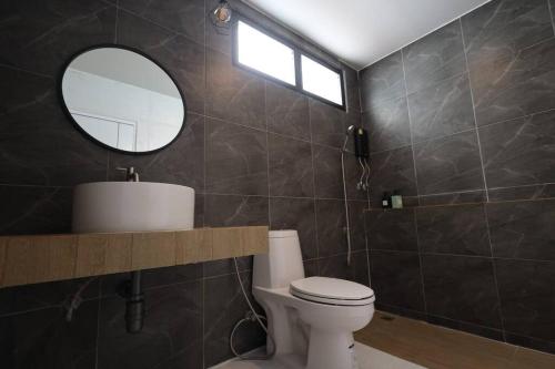 La salle de bains est pourvue de toilettes, d'un lavabo et d'un miroir. dans l'établissement Million Stars Poolvilla, à Wang Nam Khiao