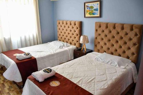 a hotel room with two beds with towels on them at CASA CAMPESTRE SANTERRA in Tacna