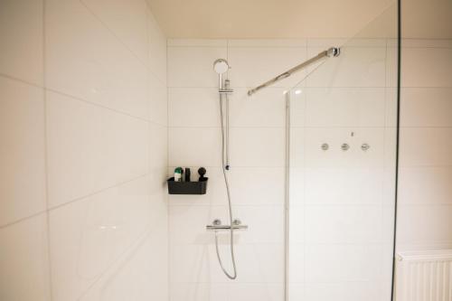 uma casa de banho com um chuveiro e uma porta de vidro em Deluxe 3 Bedroom Serviced Apartment 73m2 em Roterdã