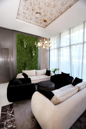 a living room with white couches and a green wall at Riviera Blue Hotel in Sunny Beach