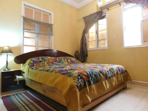 a bedroom with a bed in a room with windows at Jesiwa B's Little Palace in Accra