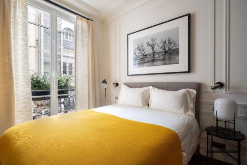 a bedroom with a yellow bed and a window at The very central location allows you to go everywhere in Paris in 30 minutes in Paris