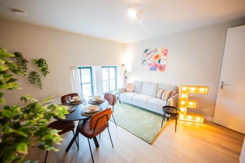 uma sala de estar com uma mesa e um sofá em Exquisite 3 Bedroom Apartment em Roterdã