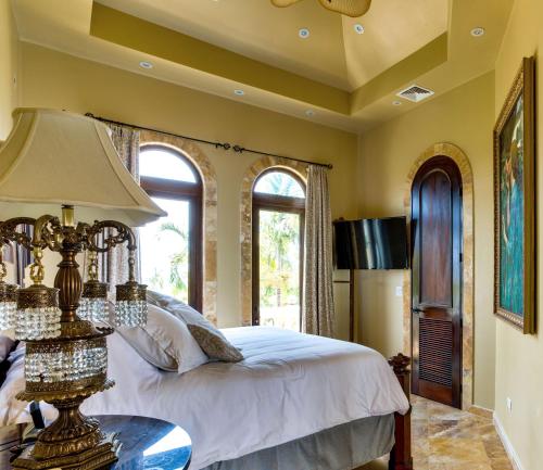 a bedroom with a bed and a table with a lamp at Villa Castello- Water Views & Resort Amenities in Placencia