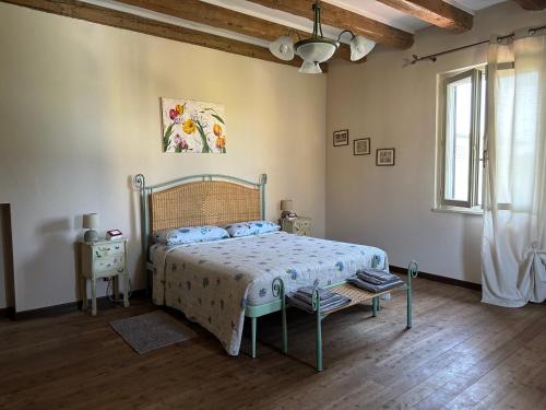 sypialnia z łóżkiem, stołem i oknem w obiekcie Cascina Maria w mieście Desenzano del Garda