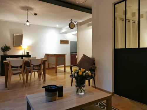 un salon avec un vase de fleurs sur une table dans l'établissement Nid douillet à quelques pas de la gare., à Carcassonne