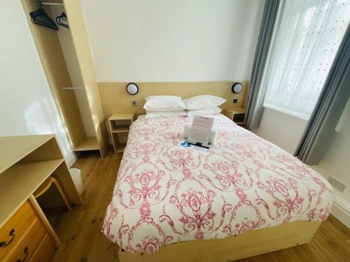 a bedroom with a bed with a laptop on it at The Danescourt in Blackpool