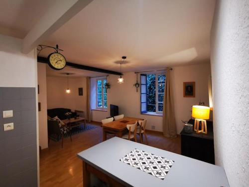 uma sala de estar e sala de jantar com um relógio na parede em Nid douillet à quelques pas de la gare. em Carcassonne