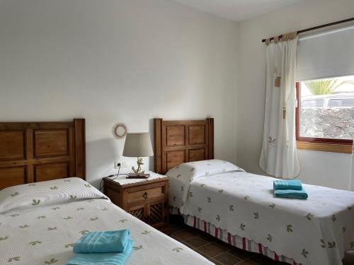 1 dormitorio con 2 camas y ventana en Villa Burgao, en Playa Blanca