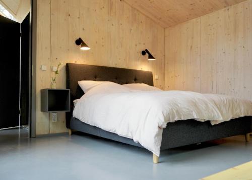 a bedroom with a large bed and a television at Elf am See - Haus 7 in Templin