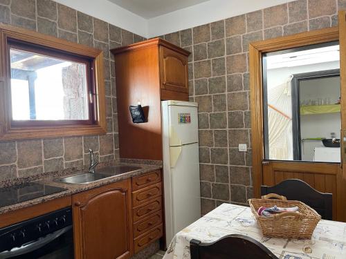 a kitchen with a sink and a refrigerator at Villa Burgao in Playa Blanca