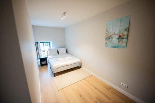 a bedroom with a bed and a painting on the wall at Flawless 3 Bedroom Apartment in Rotterdam