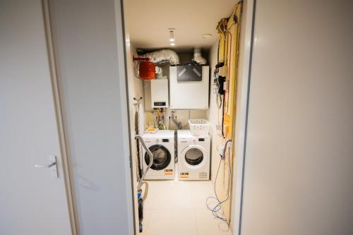 een wasruimte met een wasmachine en droger bij Flawless 3 Bedroom Apartment in Rotterdam