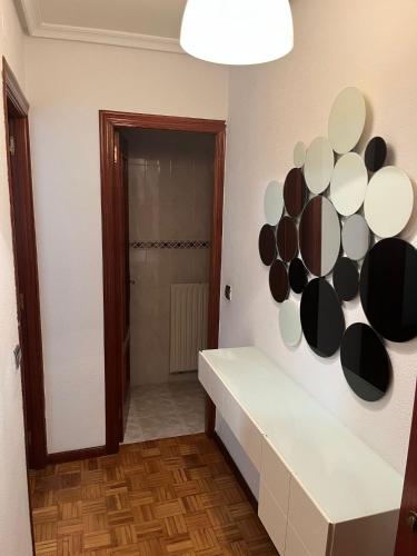 baño con encimera blanca y espejo en la pared en Coqueto apto en Maliaño, en Camargo