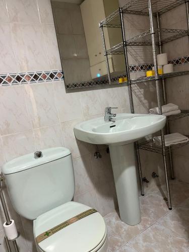 y baño con aseo blanco y lavamanos. en Coqueto apto en Maliaño, en Camargo