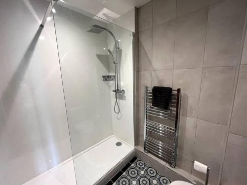 a shower with a glass door in a bathroom at Peak District Old Forge In Over Haddon in Bakewell