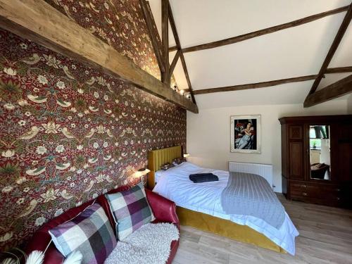 a bedroom with a bed in a room with a wall at Peak District Old Forge In Over Haddon in Bakewell