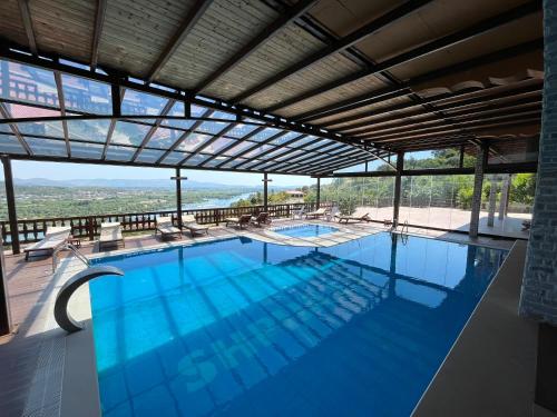 a swimming pool with a view of the mountains at Hotel Shpija e Gjyshit in Shkodër