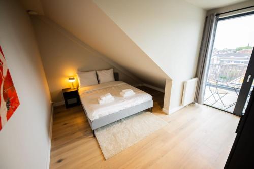 Habitación pequeña con cama y ventana grande. en Beloved 3 Bedroom Apartment en Róterdam