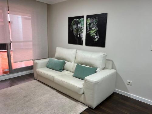 a living room with a white couch with two blue pillows at Gran terraza muy centrico in Vigo